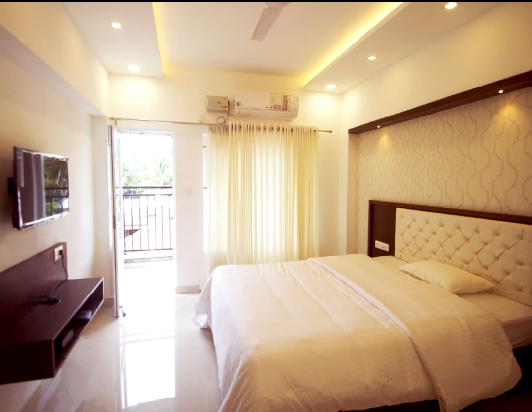 Studio apartment bedroom with balcony access and wall-mounted TV